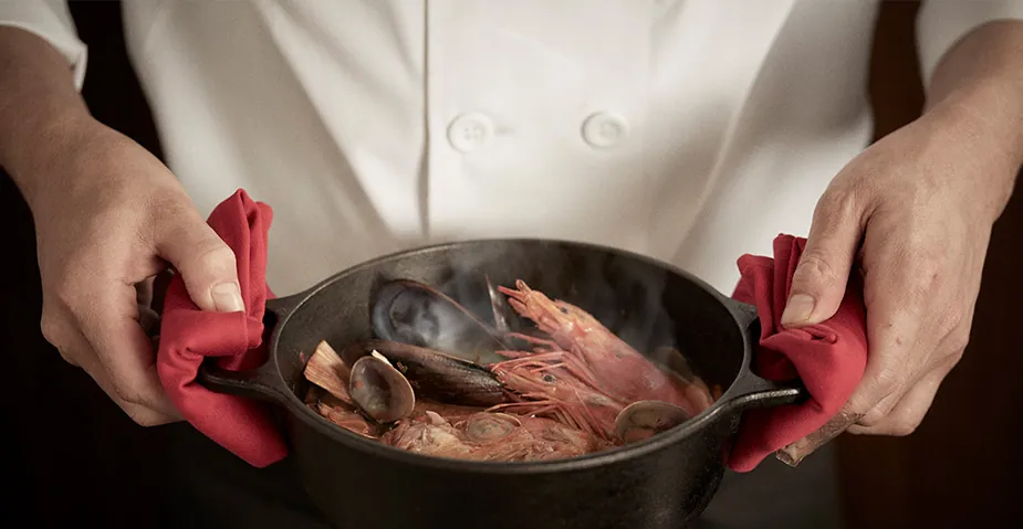 EX chef holding a pot with red handles