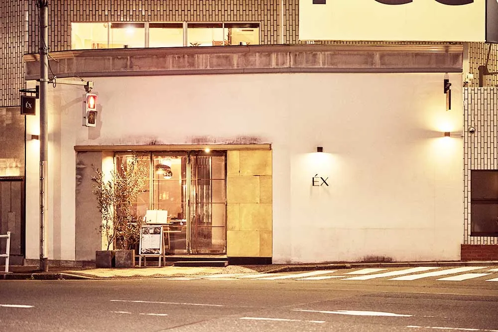 Storefront with the "ÉX" sign at night